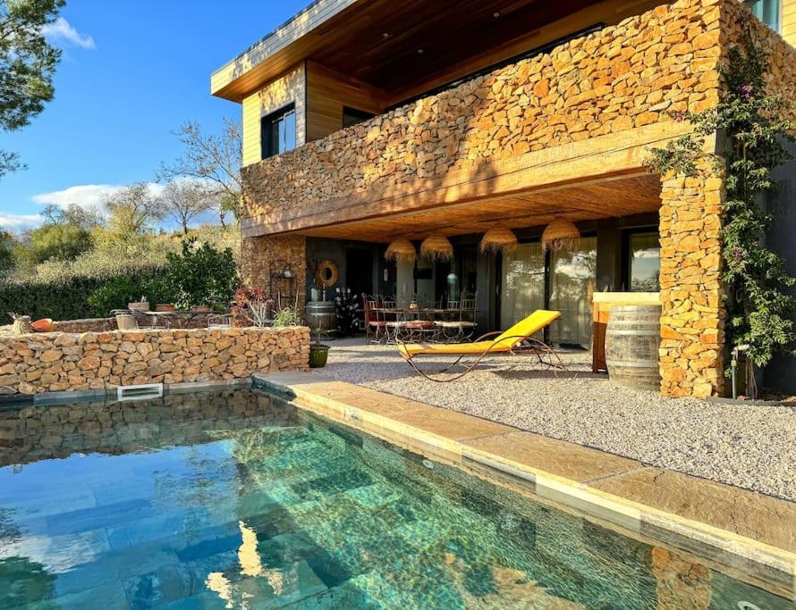 a house with a swimming pool in front of a house at Maison d'hôtes Les Oliviers in Cazouls-lès-Béziers