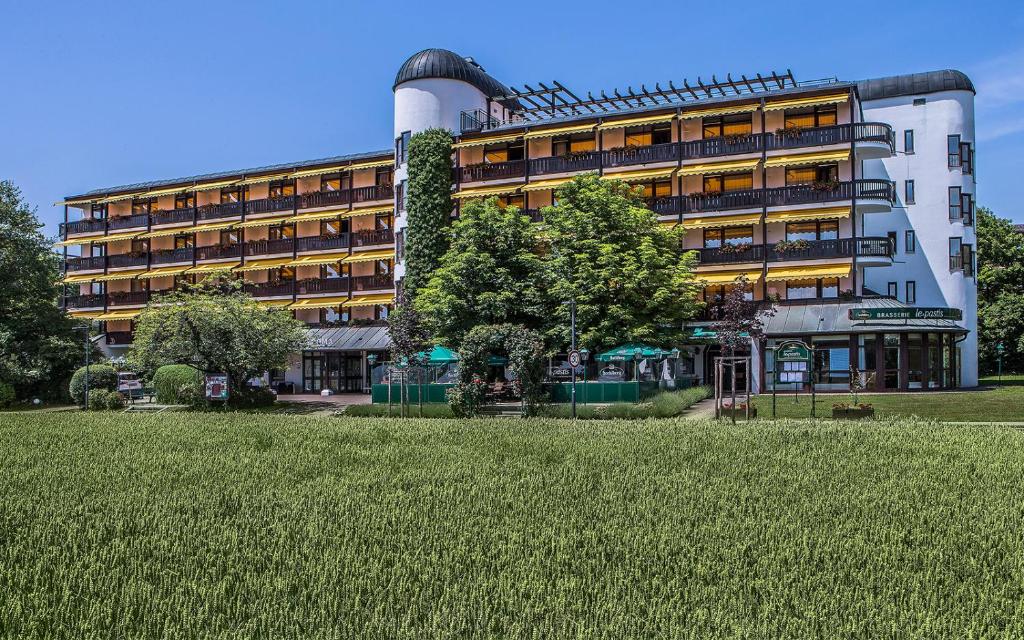 ein großes Gebäude mit einem Grasfeld davor in der Unterkunft Johannesbad Thermalhotel Ludwig Thoma in Bad Füssing