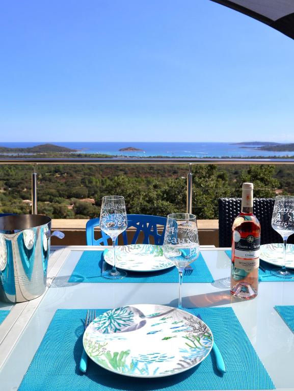 - une table avec une bouteille de vin et des verres dans l'établissement Villa Leana Villata, à Sainte-Lucie de Porto-Vecchio