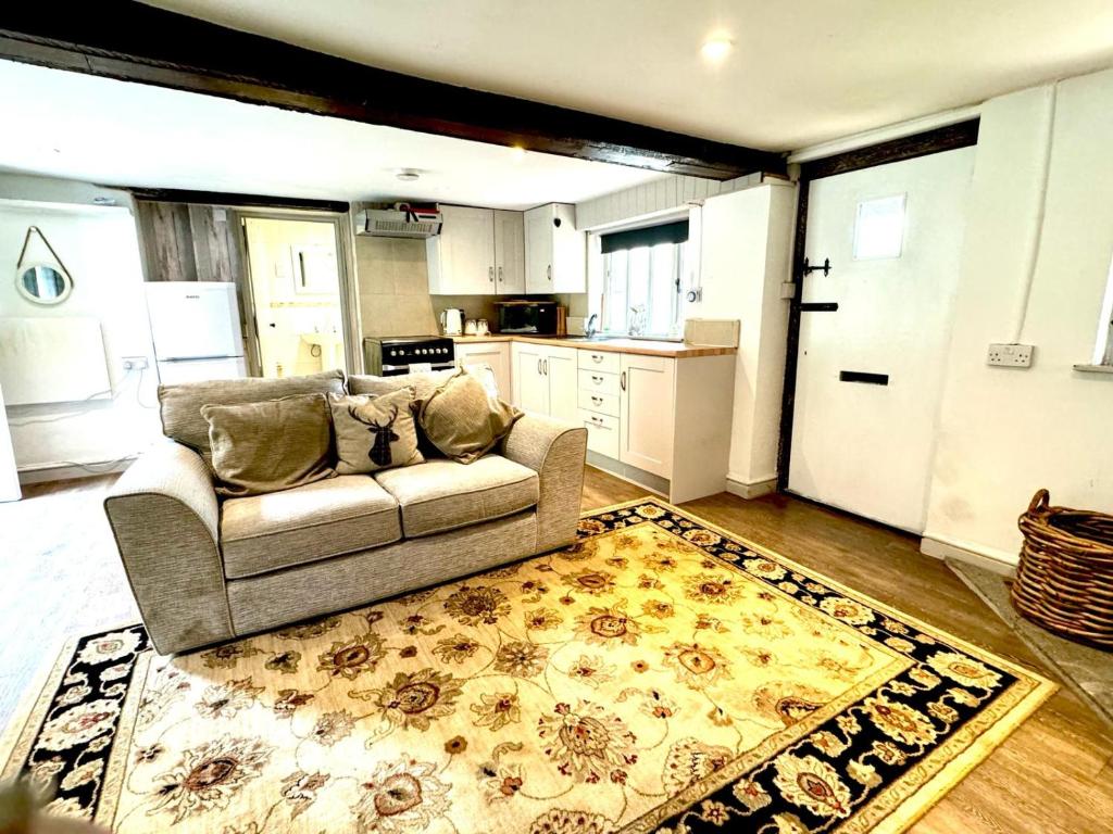 un soggiorno con divano e tappeto di Stable boys cottage a Sedgeberrow