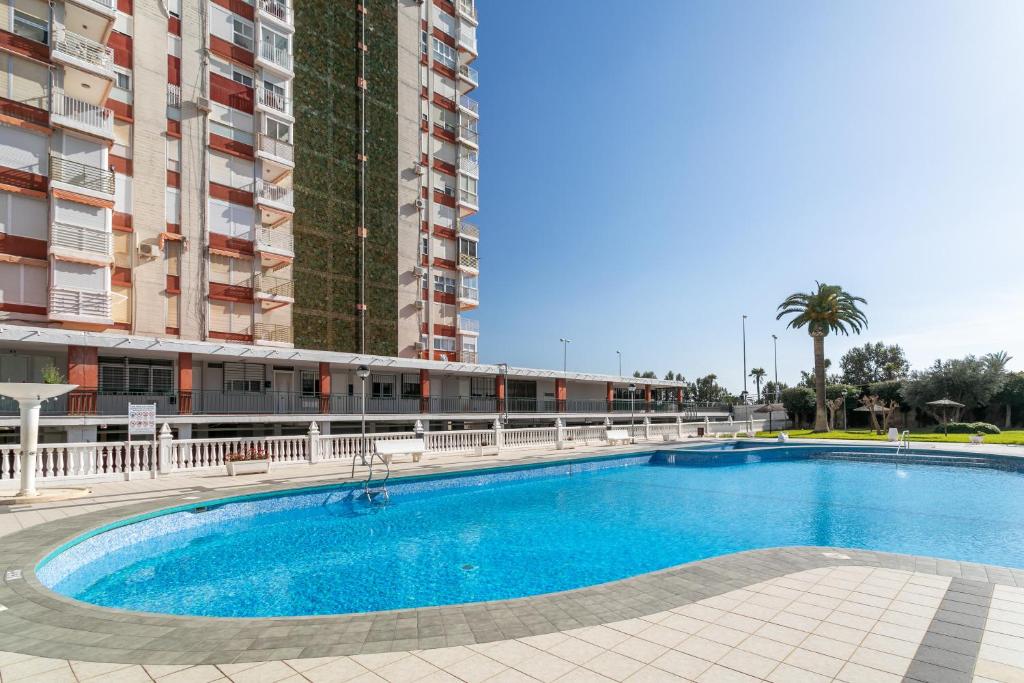 uma piscina em frente a um edifício alto em Primera línea de playa em Alicante