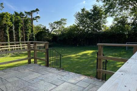 a wooden fence next to a field of grass at The Lockett by StayStaycations in Plymouth