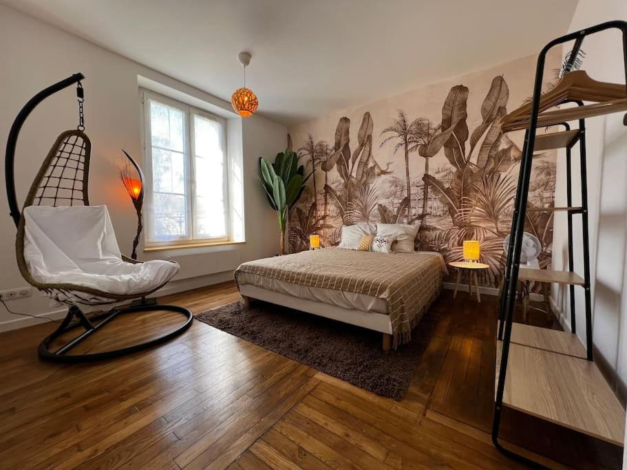 um quarto com uma cama e uma cadeira em Grand F2 proche du centre ville. em Châlons-en-Champagne
