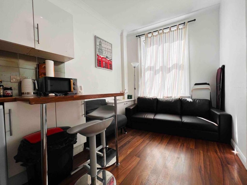 een woonkamer met een zwarte bank en een tafel bij 3-Bed Apartment in King's Cross Central London in Londen