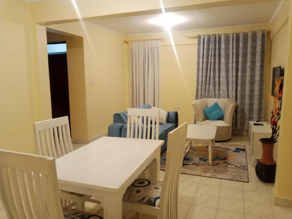 a dining room and living room with a table and chairs at Jabali- Zuriel homes 1 bedroom apartment in Kakamega
