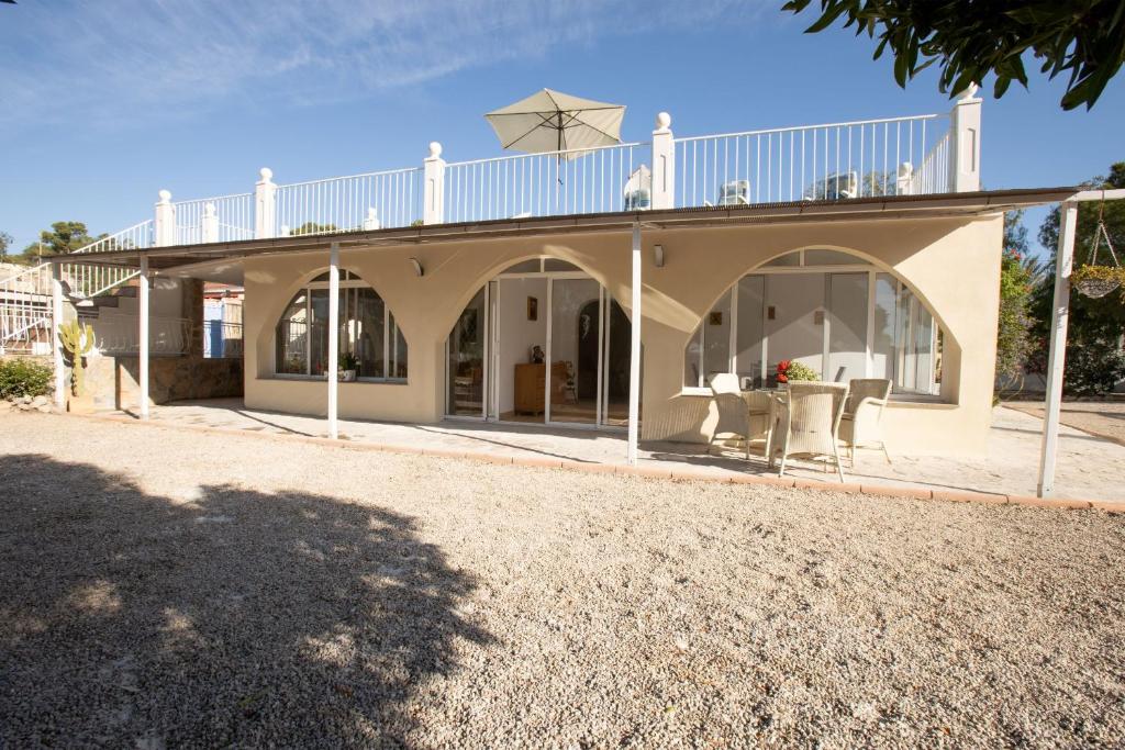 a house with a balcony on top of it at Garten und Pool in San Vicente del Raspeig