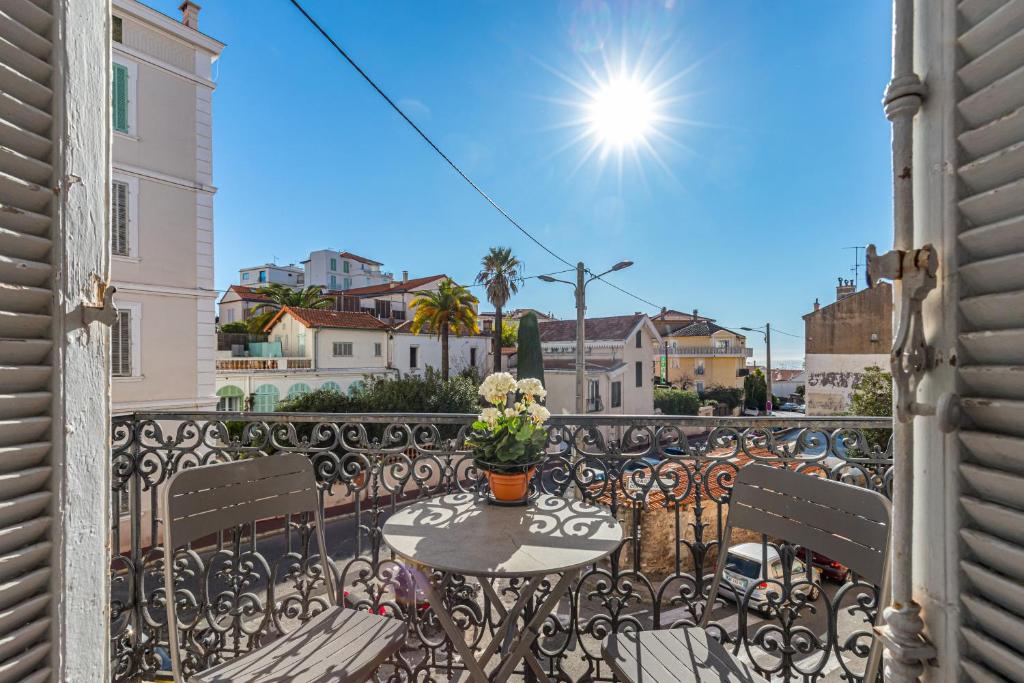 un patio avec une table et des chaises sur un balcon dans l'établissement 77 Avenue de Grasse, à Cannes