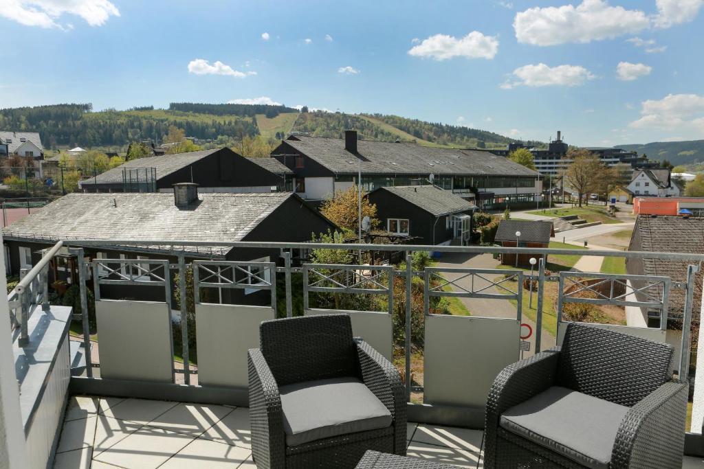 ein Balkon mit zwei Stühlen und Blick auf die Stadt in der Unterkunft Fewo on the Top in Willingen
