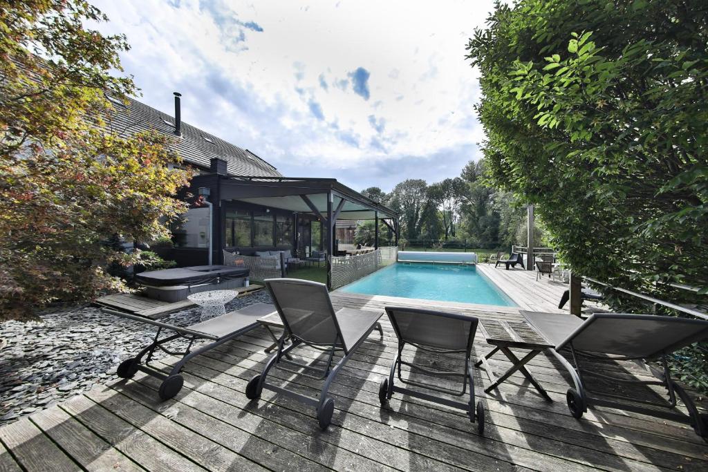 eine Terrasse mit 2 Stühlen und einem Pool in der Unterkunft Ancienne grange rénovée esprit Loft in Dietwiller