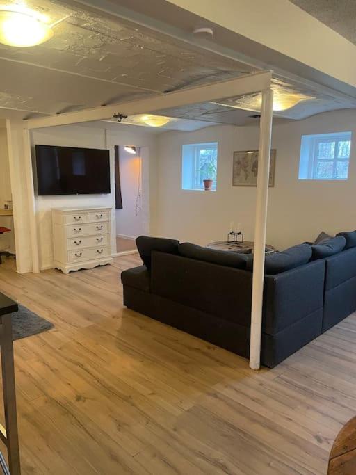 a living room with a couch and a flat screen tv at Hyggeligt gæstehus in Kjellerup