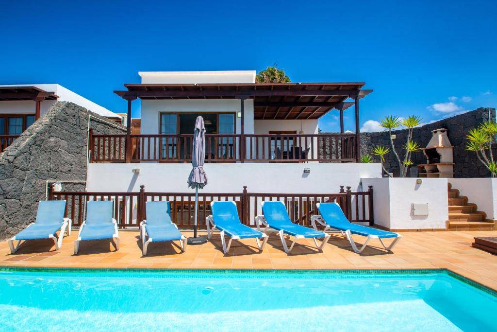 une villa avec une piscine, des chaises et une maison dans l'établissement Playa Blanca Vista Lobos Villa with sea view, à Playa Blanca