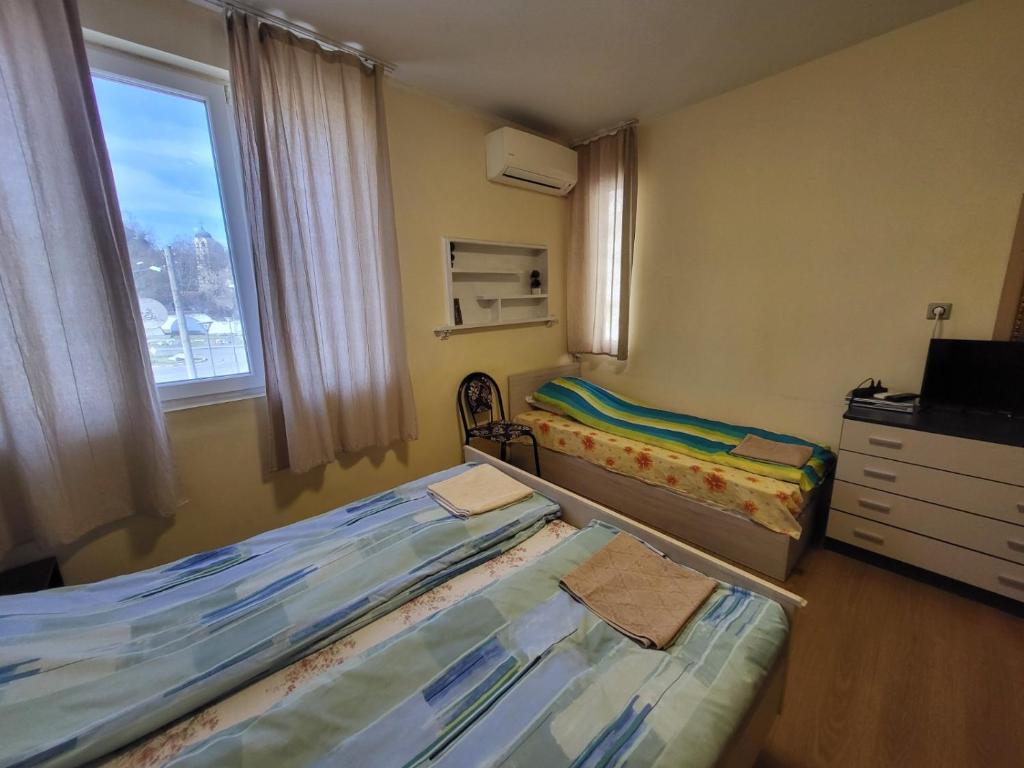 a small room with two beds and a window at East Gate Guest Rooms in Plovdiv
