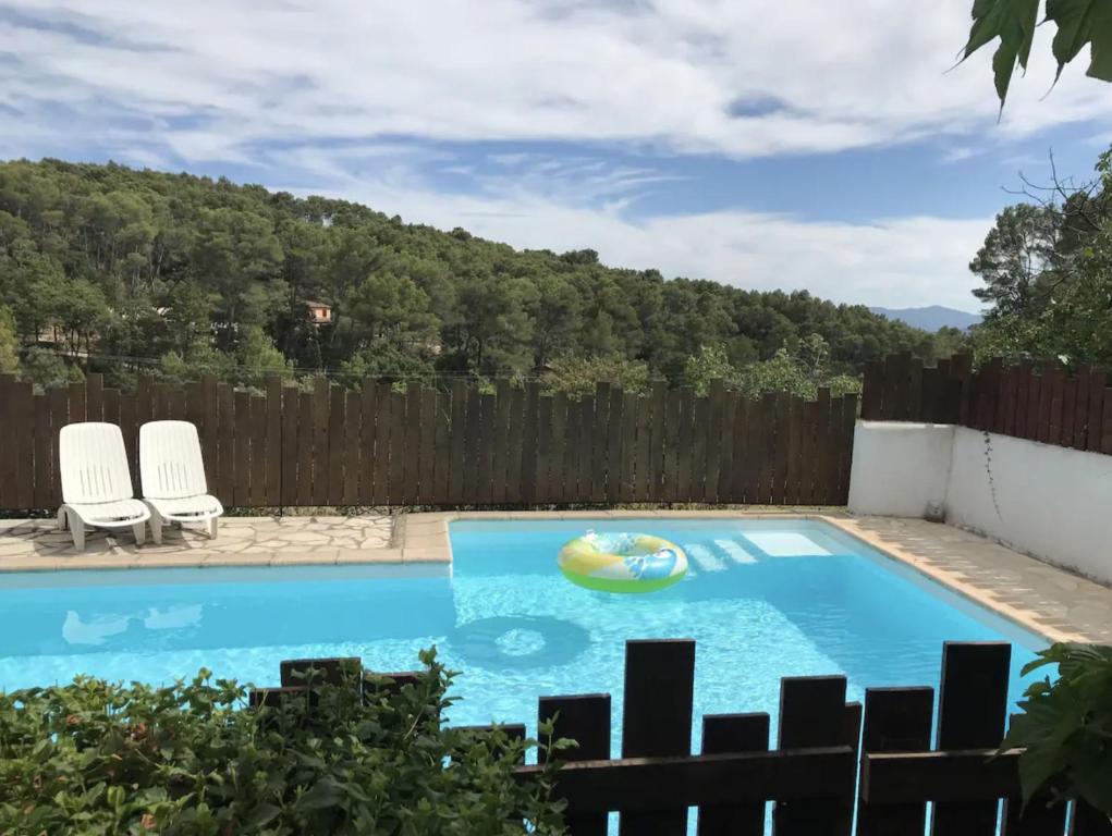 uma piscina num quintal com uma cerca de madeira em Labussiere em Lorgues