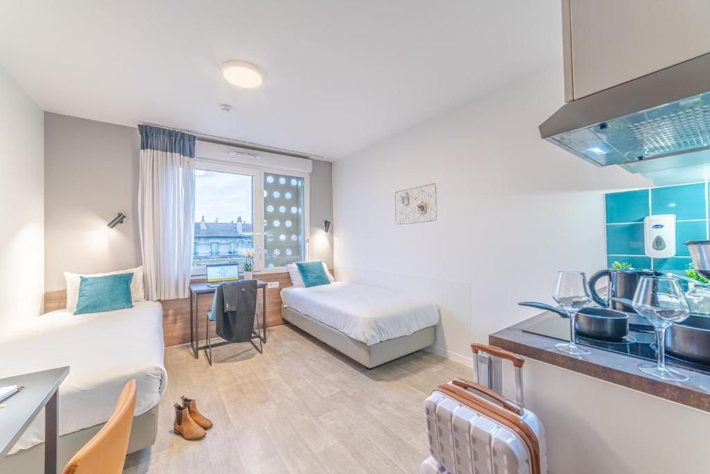 a hotel room with a bed and a kitchen and a room at Break & Home Paris Italie Porte de Choisy in Ivry-sur-Seine