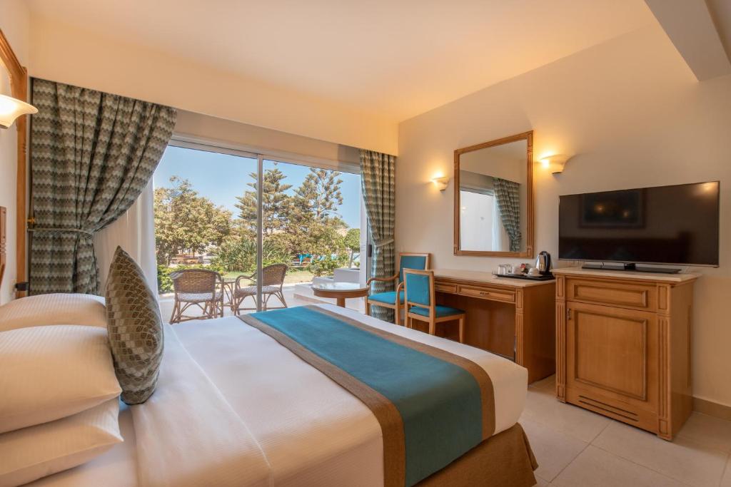 Hurghada Long Beach Resort في الغردقة: غرفة فندقية بسرير ونافذة كبيرة