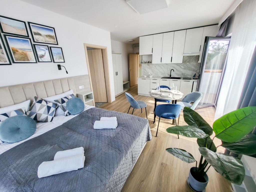 sypialnia z dużym łóżkiem z niebieskimi krzesłami w obiekcie Hotel Gorzelanny i Apartamenty Dźwirzyno w Dźwirzynie