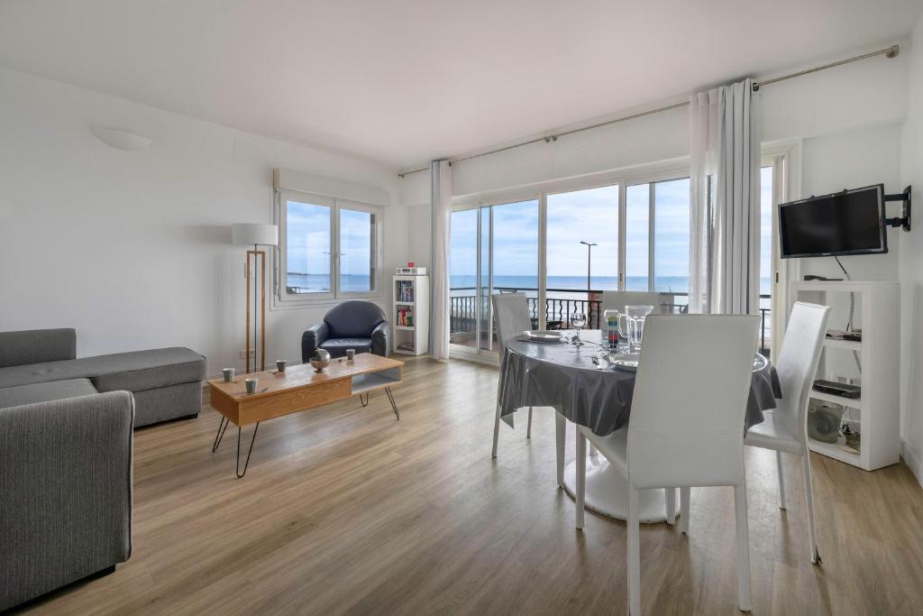un salon avec une table et un canapé dans l'établissement Séjour à 4 - Les pied dans l'eau - Vue mer, à La Baule