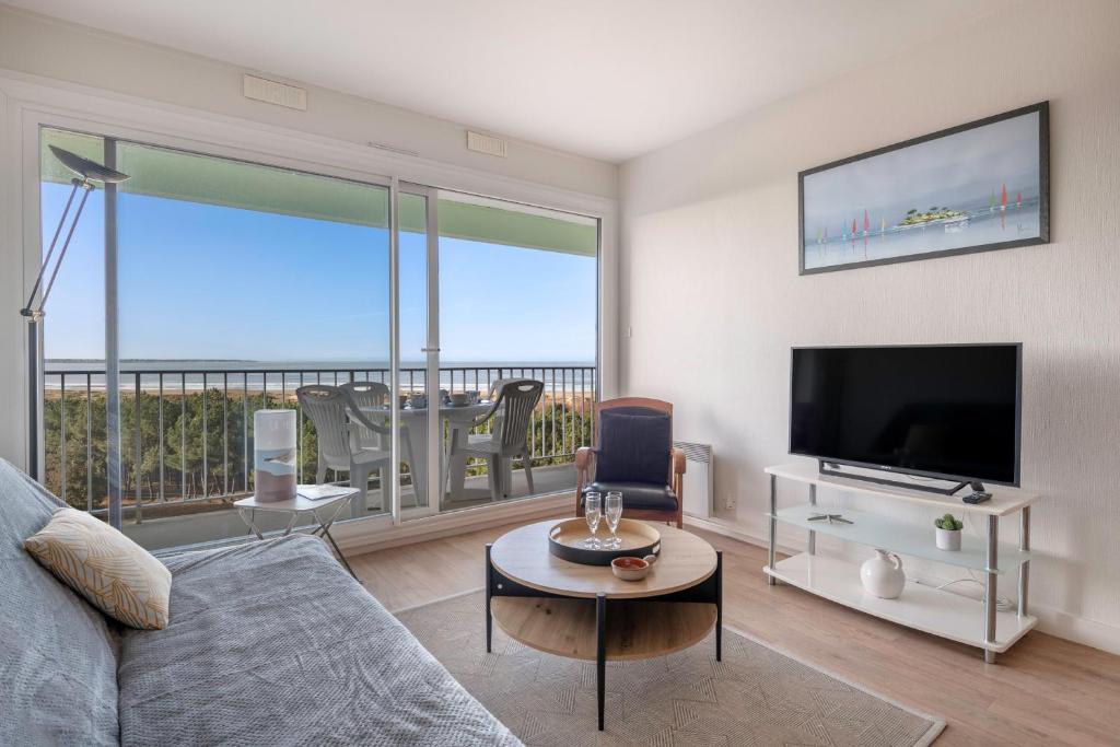 a living room with a couch and a flat screen tv at Appartement face mer pour 4 à Saint Brévin L’Océan in LʼErmitage