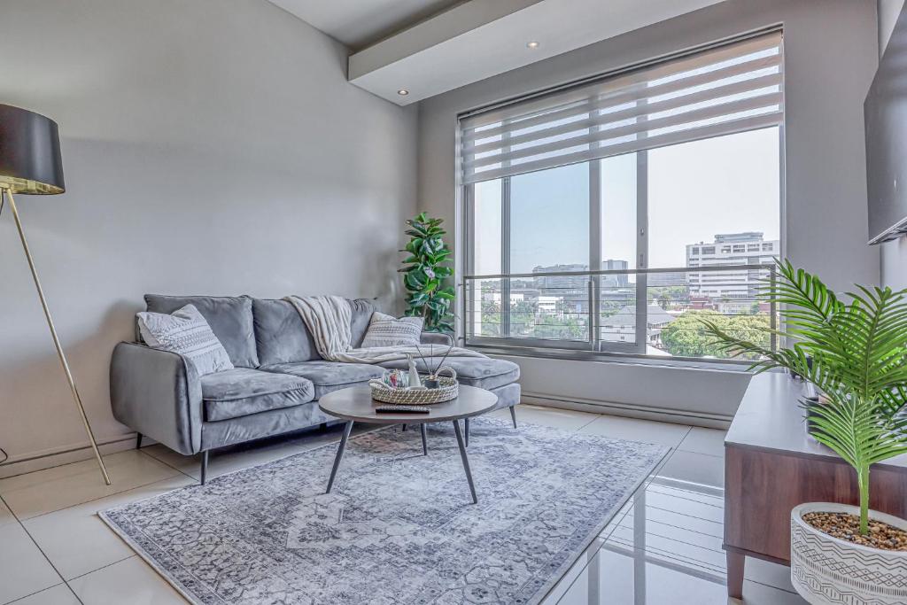 a living room with a couch and a table at Luxurious One Bedroom Apartment In Sandton in Johannesburg
