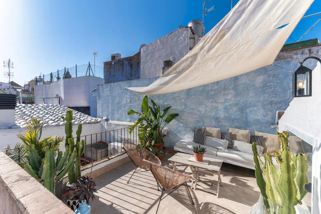 un patio all'ultimo piano con divano, sedie e cactus di Casa Azul by Hello Homes Sitges a Sitges