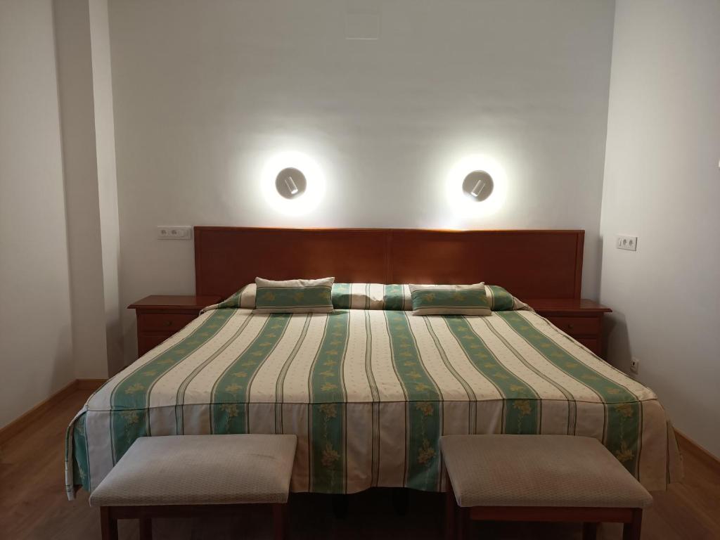 a bedroom with a bed with a green and white comforter at La Luna Blanca in Torremolinos