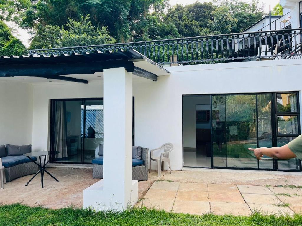 a white house with glass doors and a patio at Le Bamboo Guest House And Boat Cruise in Hartbeespoort