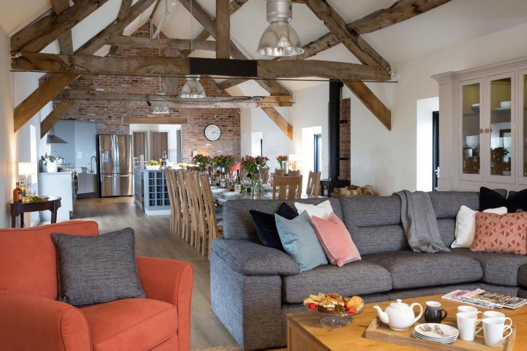 a living room with a couch and a dining room at The Barn at Plas Ashpool Sleeps 8 in Llandyrnog