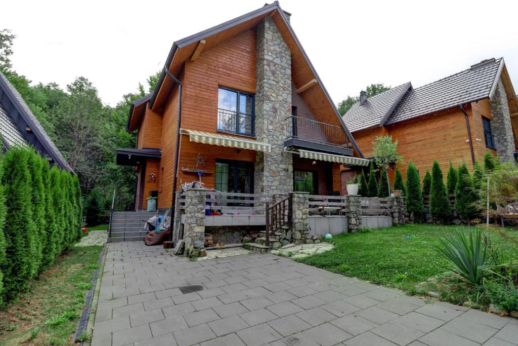 a large wooden house with a patio in front of it at Captivating 3-Bed Villa in Brezovica Ski Centre in Brezovica