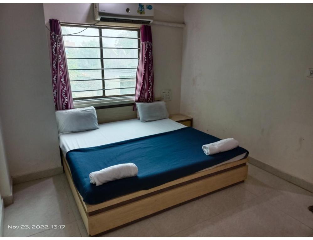 a small bedroom with a bed with a window at Hotel Shiv Sadan, Somnath in Somnath
