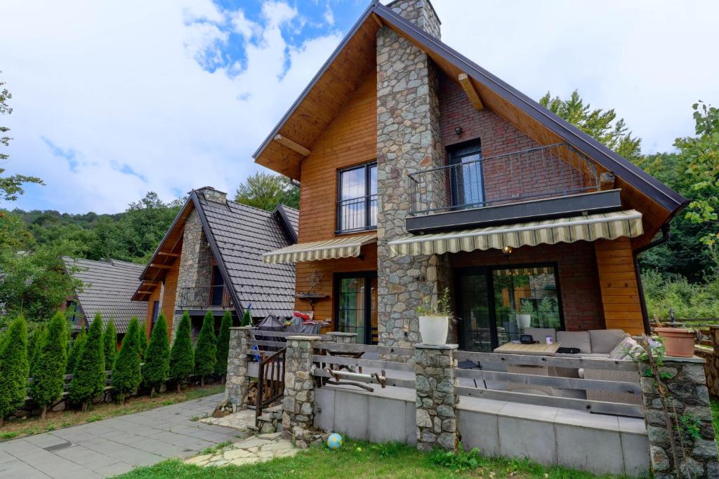 a log home with a wrap around porch at 3 Bed Villa Sleeps 8 - Sauna Spa Parking in Brezovicë