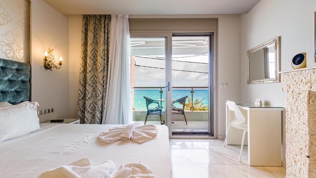 a bedroom with a bed and a view of the ocean at Art Luxury Suites in Pefkohori