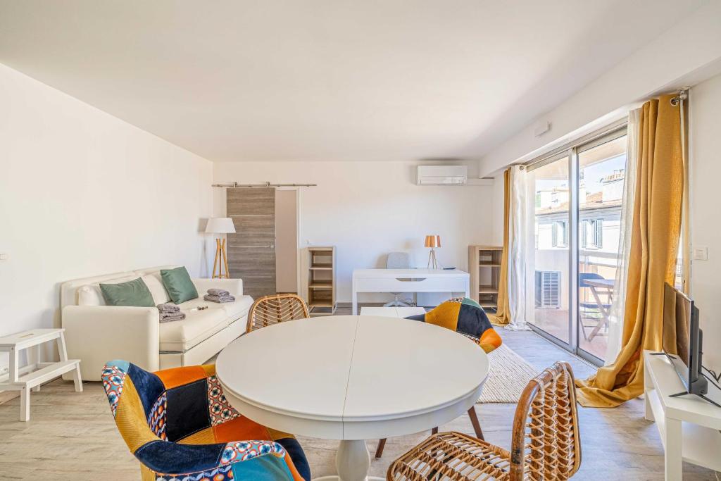 un salon avec une table et des chaises blanches dans l'établissement Exceptional spacious one bedroom flat in Cannes, à Cannes