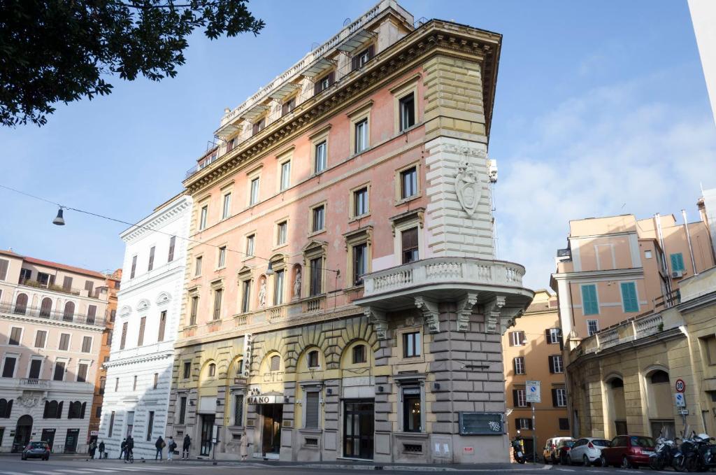 ein hohes Gebäude mit einem Turm davor in der Unterkunft Hotel Traiano in Rom