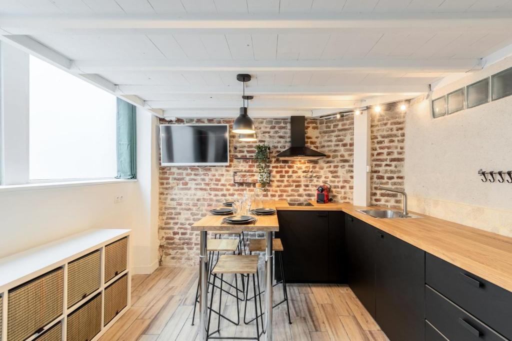 uma cozinha com um balcão e um bar com bancos em Atypical flat in the centre of Lille. em Lille