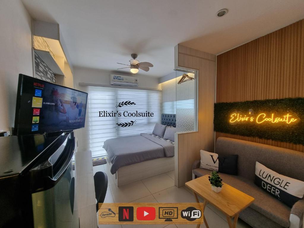 a small living room with a bed and a television at Tagaytay affordable staycation by Elixir's Coolsuite in Tagaytay