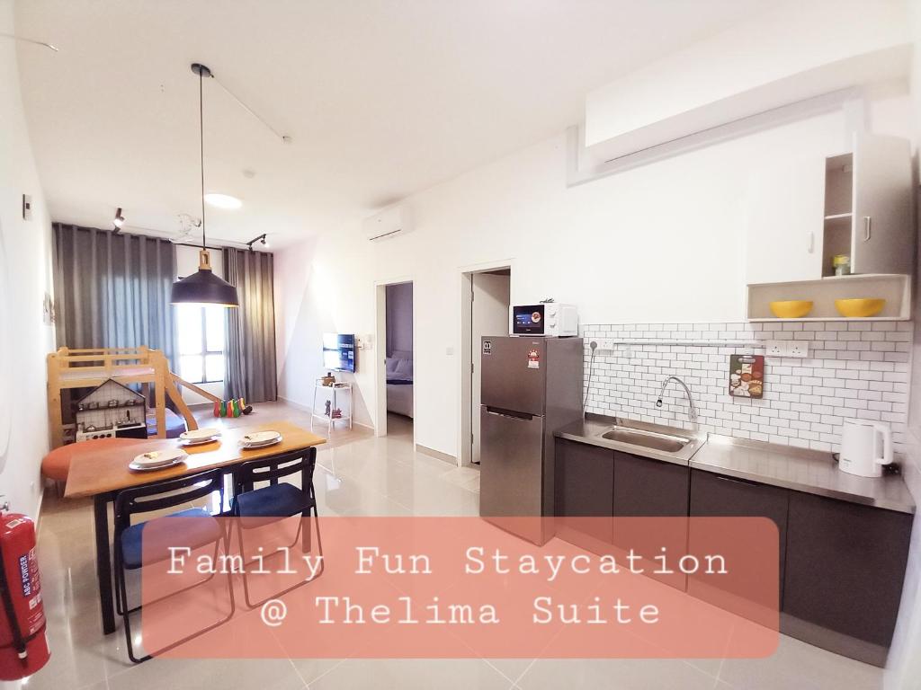 a large kitchen with a table and a counter top at Family Fun Staycation @ Thelima Suite in Kajang