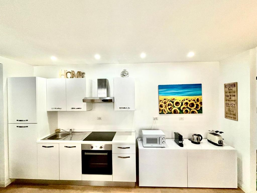 a white kitchen with a sink and a microwave at Matilda Guest House EUR 4 posti letto in Rome