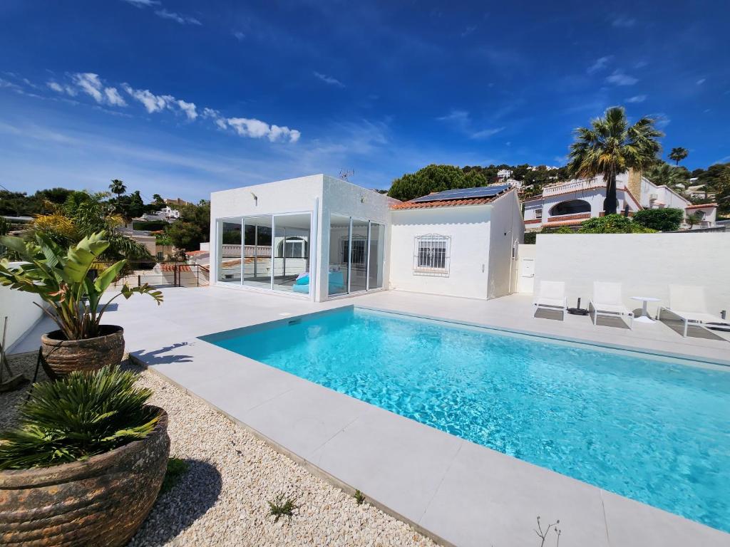 a swimming pool in the backyard of a house at Villa Blue Lagoon Moraira in Moraira