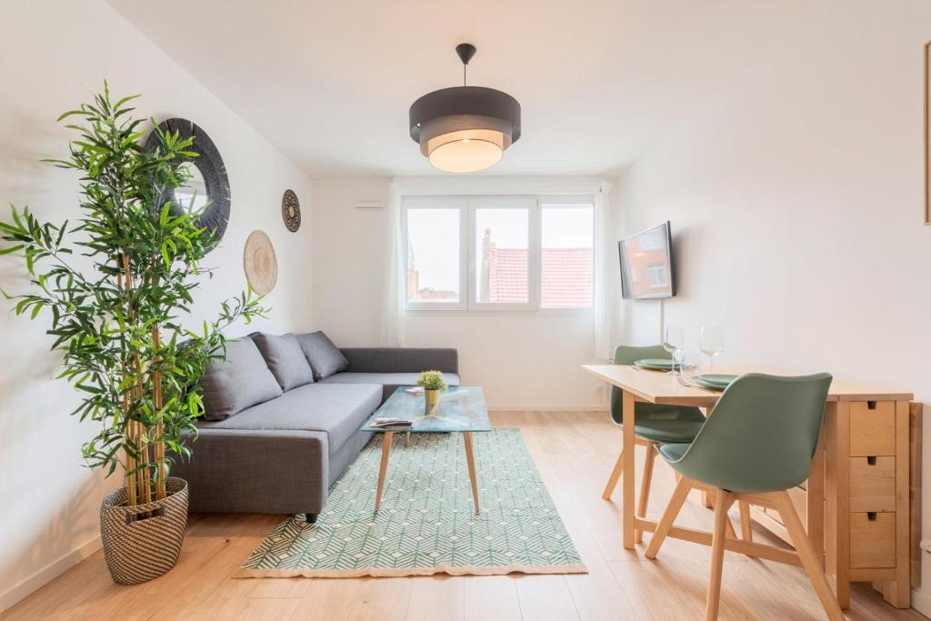 un salon avec un canapé et une table dans l'établissement Lille, fully-equipped apartment with parking space, à Lille
