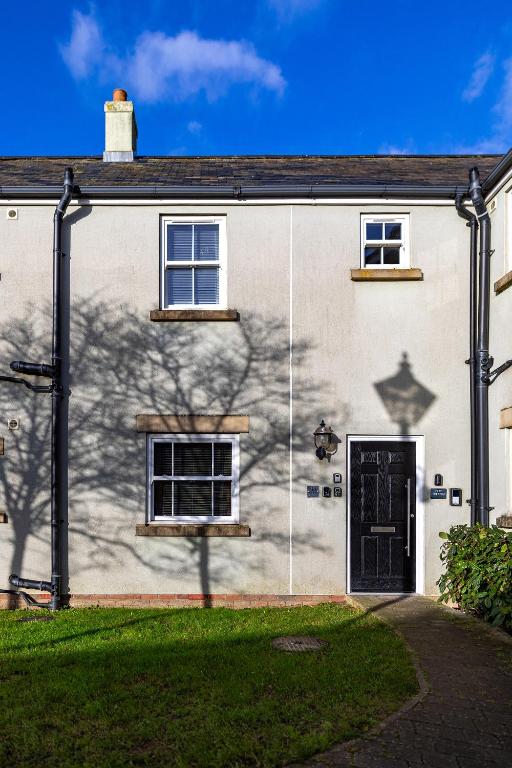 a white house with a black door and windows at Filey Hideaway Apartment The Bay Holiday Village Filey Homesweetholidayhomes in Filey