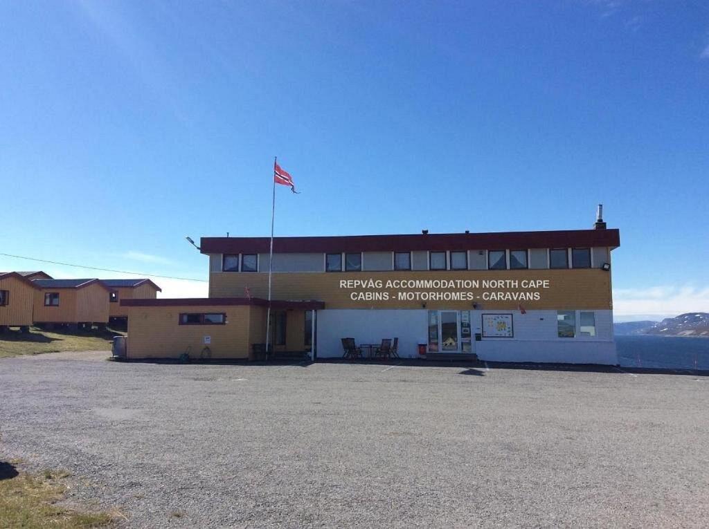 a building with an american flag on top of it at Repvåg Overnatting Nordkapp in Repvåg