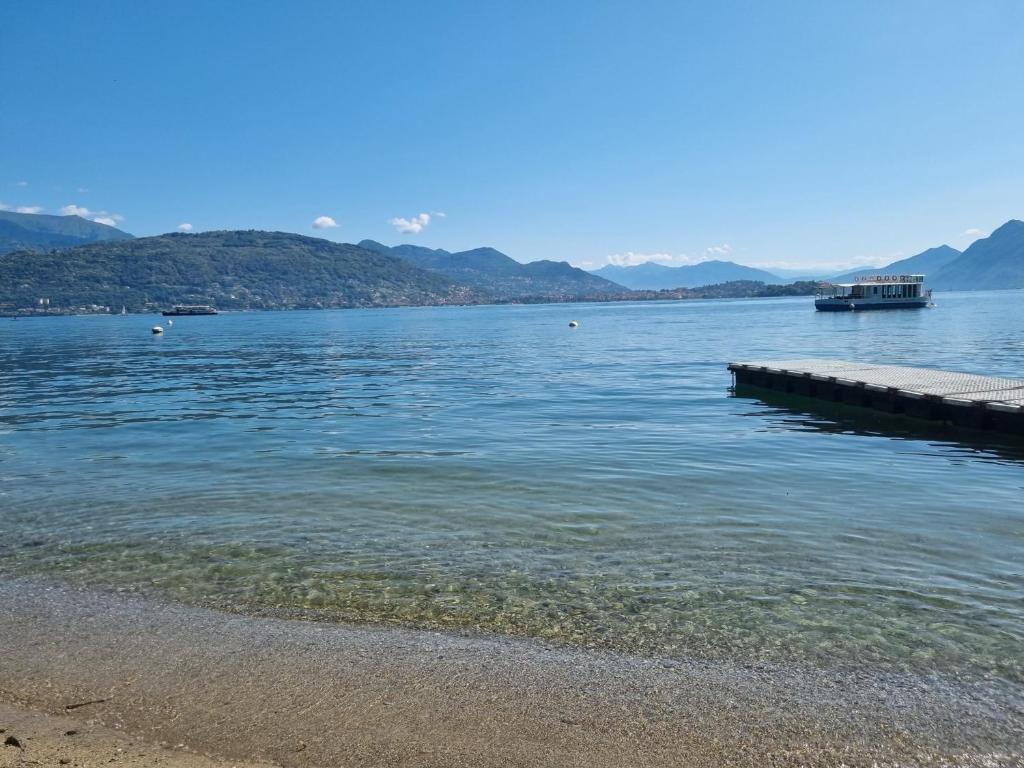 a body of water with a pier and mountains at Apartment camelie with private beach in Baveno
