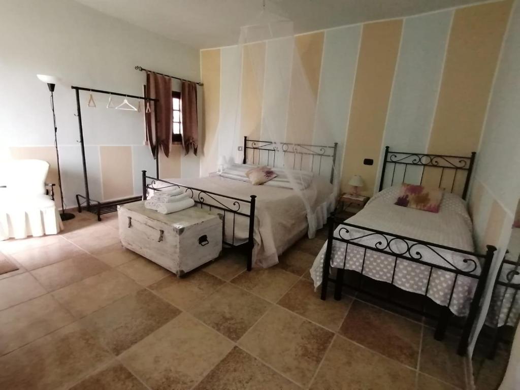 塞莫內塔的住宿－Casale Cavatella，一间带两张床的卧室,铺有瓷砖地板。