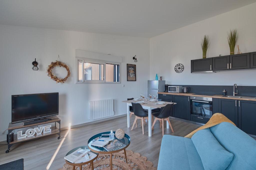 un salon avec un canapé bleu et une table dans l'établissement La Petite Maison Cocooning - De plain pied, à Mésanger