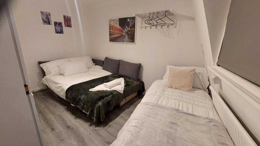 a small room with a bed and a bed and a couch at 2-Bed Apartment in King's Cross Central London in London