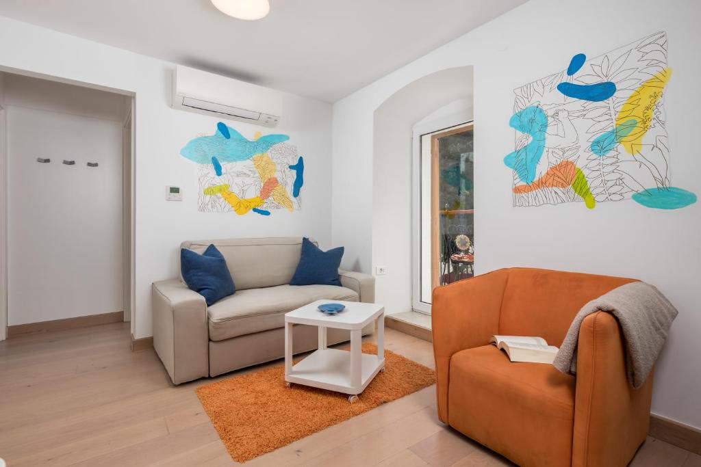 a living room with a couch and a chair at Apartments Anaika at the beach, Opatija in Ika