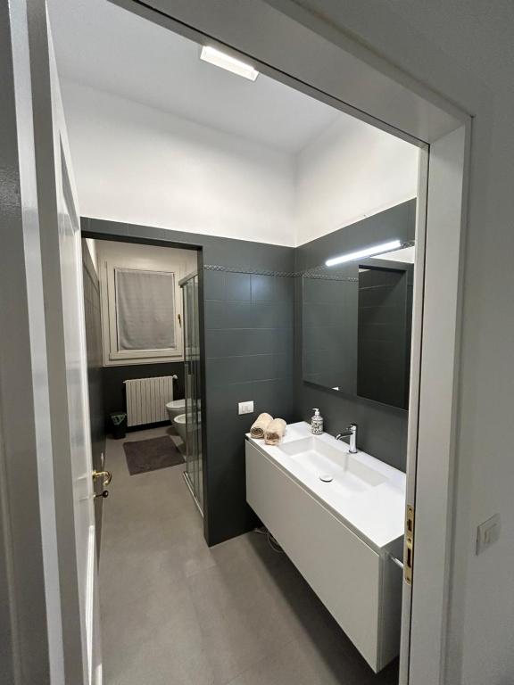 een badkamer met een witte wastafel en een spiegel bij AMIA rooms & wine in Valdobbiadene