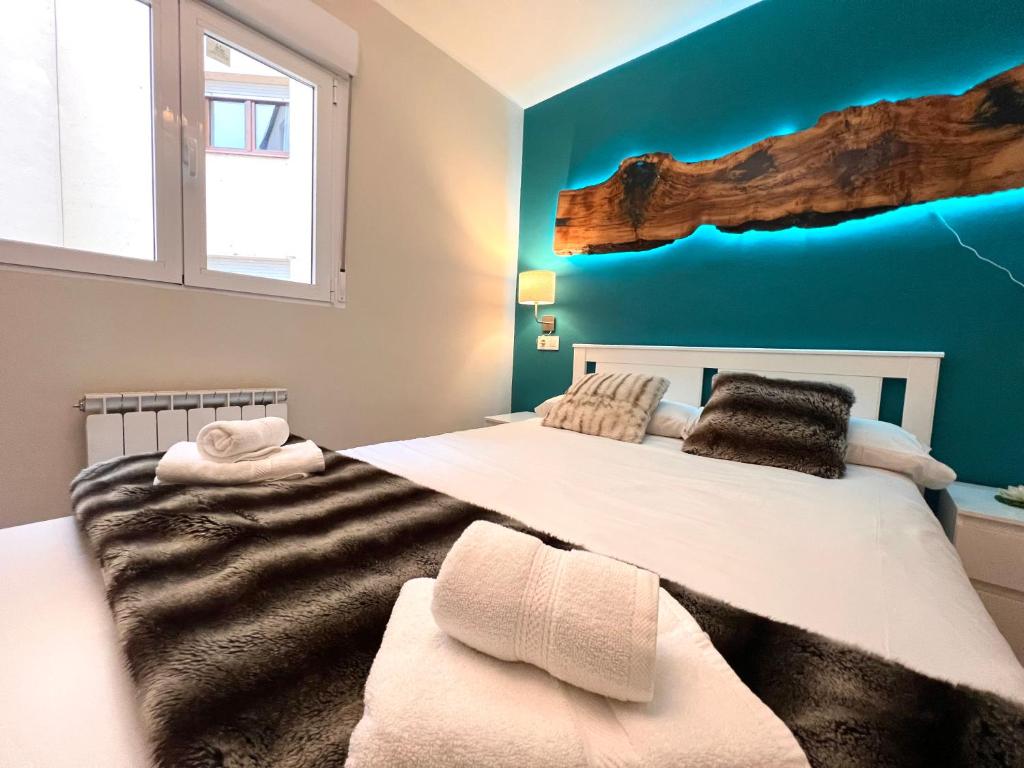 um quarto com uma cama grande e uma parede azul em Apartament Les Vernedes em Sort