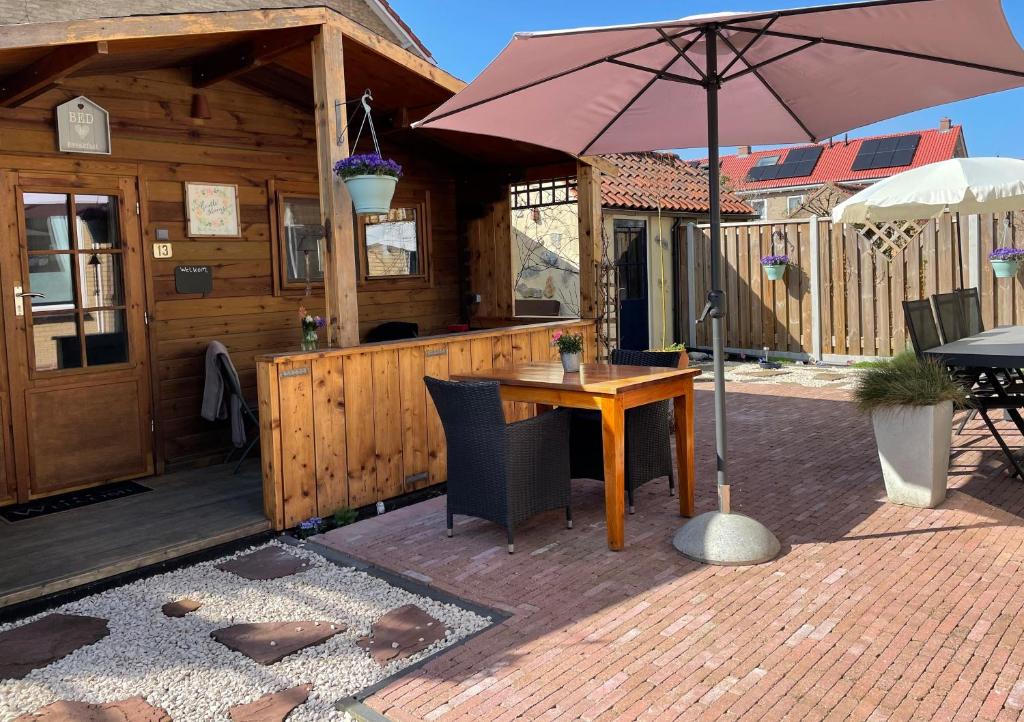 a wooden cabin with a table and an umbrella at B&B Diemerplein in Amsterdam