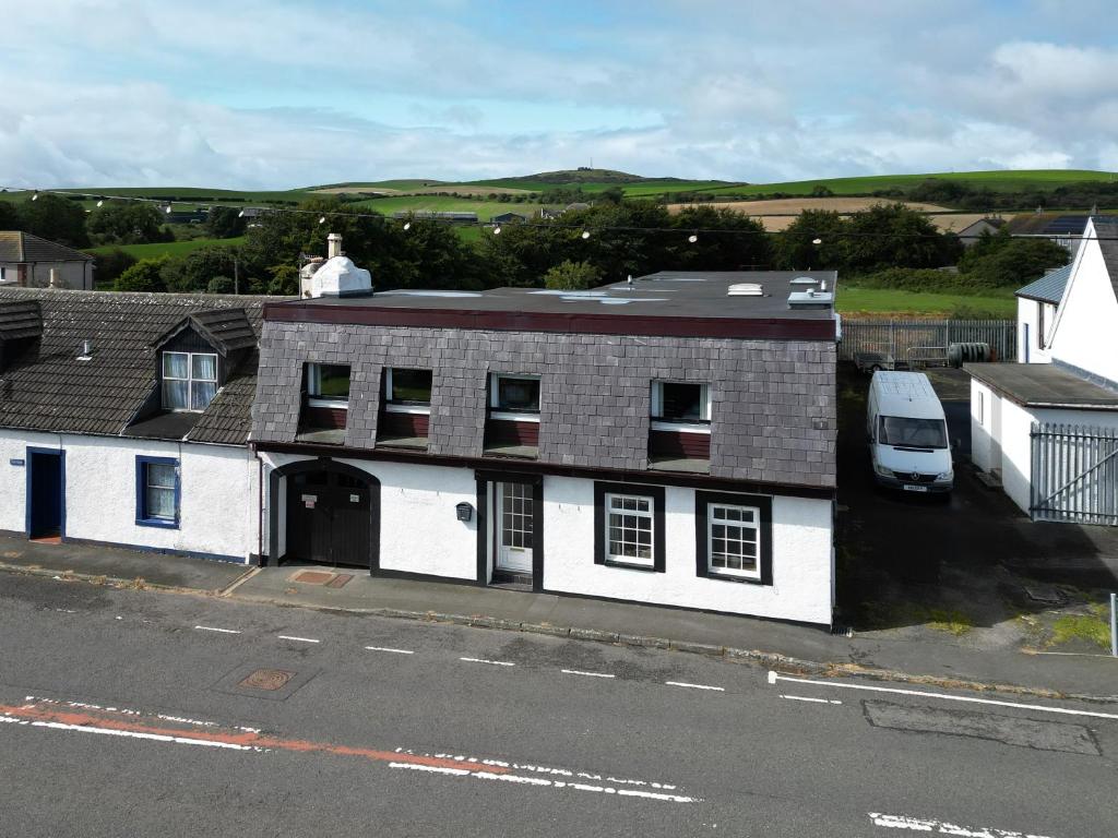 a white house with a van parked in front of it at Lochans Lodge in Stranraer